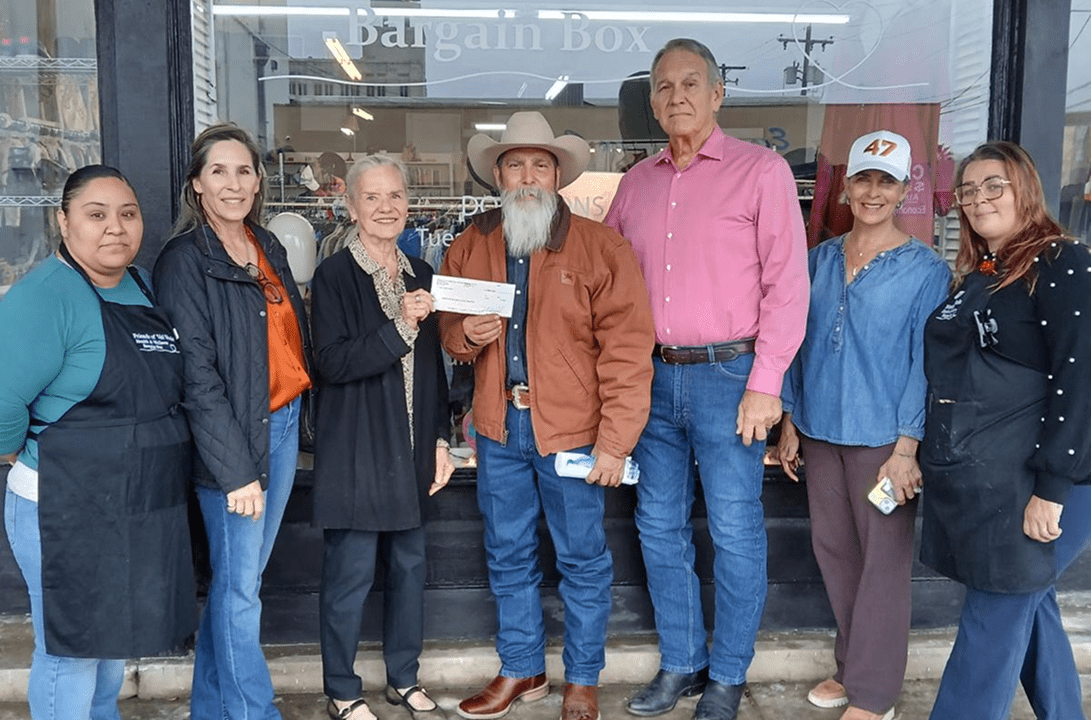 Seven people presenting a donation check