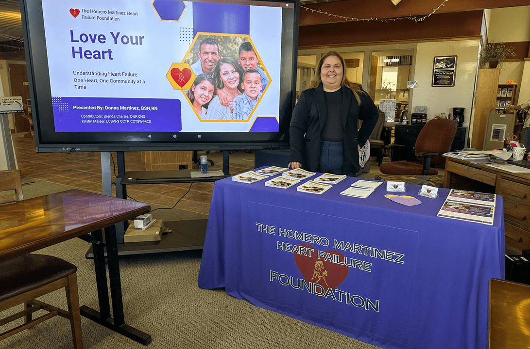 Woman standing behind heart health information table
