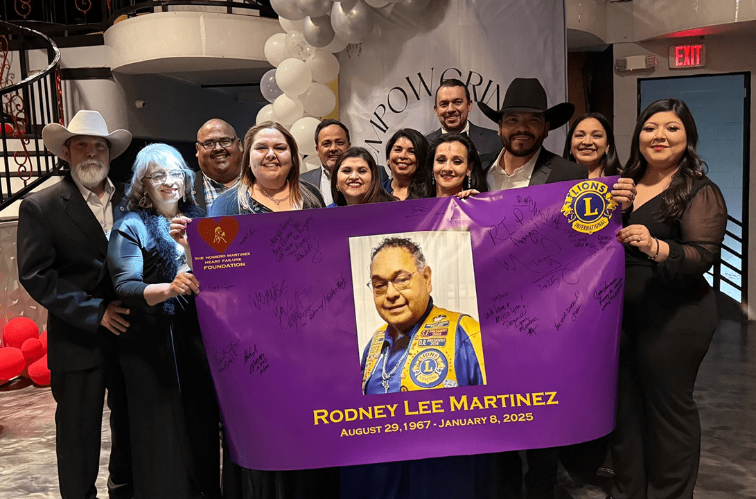Group holding purple memorial banner and balloons