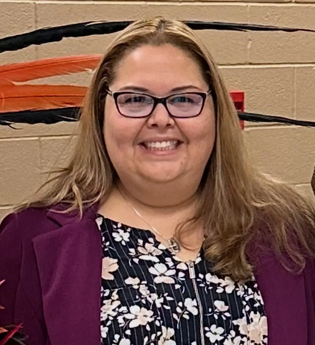 Smiling woman wearing glasses and purple blazer